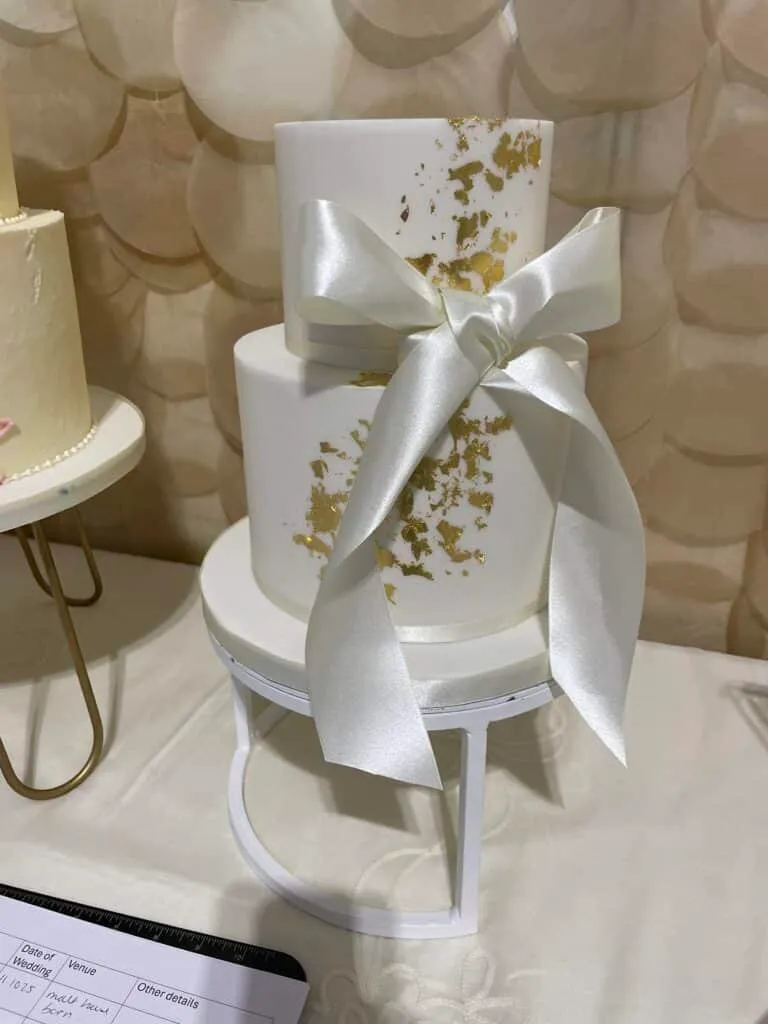 White Iced Wedding Cake, gold leaf and satin bow